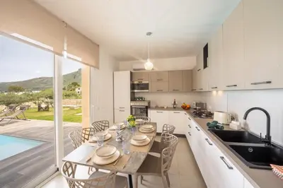 a kitchen and dining room with a table and chairs at Villa Soho in Castellammare del Golfo