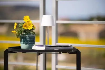 a table with a vase of flowers and a lamp at Villa Soho in Castellammare del Golfo