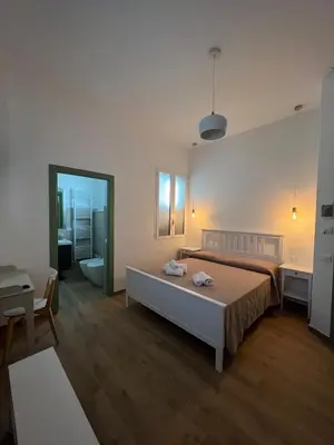 a bedroom with a bed and a desk and a mirror at MGrooms in Palermo