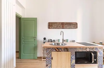 a kitchen with a sink and a green door at MGrooms in Palermo