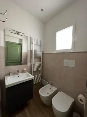 a bathroom with a sink and a toilet and a mirror at MGrooms in Palermo
