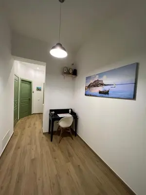 a room with a desk and a painting on the wall at MGrooms in Palermo