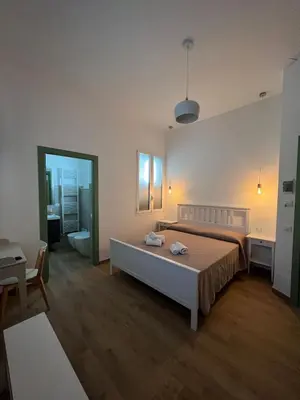 a bedroom with a large bed and a bathroom at MGrooms in Palermo