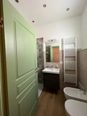 a bathroom with a toilet and a sink and a door at MGrooms in Palermo