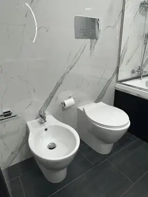a white bathroom with a toilet and a sink at Maisondedesign in Palermo