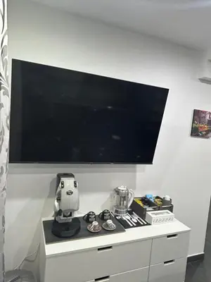 a large flat screen tv on a white wall at Maisondedesign in Palermo