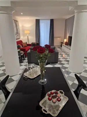 a living room with a table with a vase of roses at Colonne San Domenico in Palermo