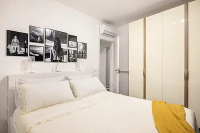 a bedroom with a white bed with four pictures on the wall at Colonne San Domenico in Palermo