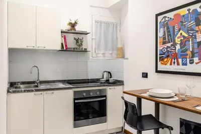 a kitchen with white cabinets and a wooden table at Colonne San Domenico in Palermo