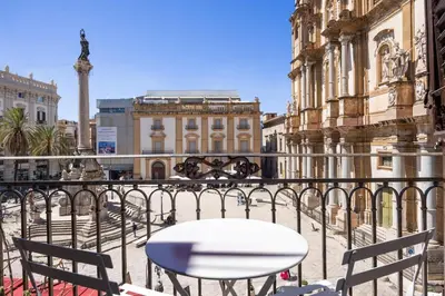 a white table and chairs on a balcony with buildings at Colonne San Domenico in Palermo
