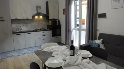 a kitchen with a table with a bottle of wine at Stella di mare Acquamarine in Balestrate
