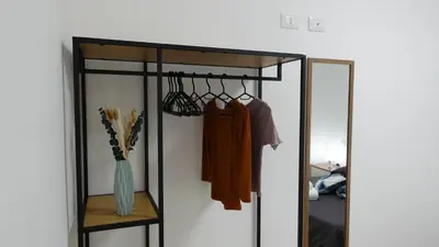 a sliding glass closet door with a shelf and clothes at Stella di mare Acquamarine in Balestrate