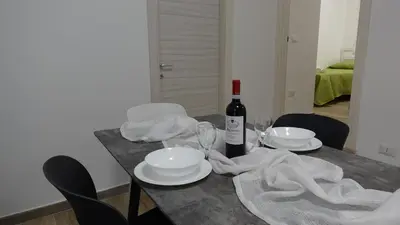 a table with a bottle of wine and plates and glasses at Stella di mare Acquamarine in Balestrate