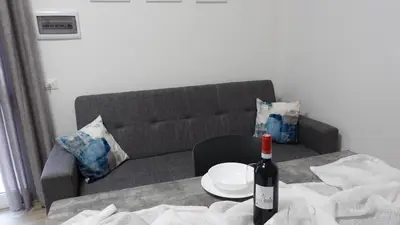 a bottle of wine on a table in front of a couch at Stella di mare Acquamarine in Balestrate