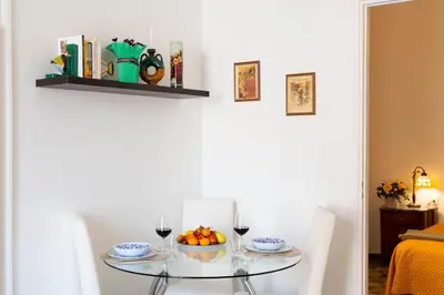 a table with a bowl of fruit and two glasses of wine at Piano Imperiale Home in Palermo