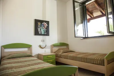 a bedroom with two beds and a window at Borgomare in Campofelice di Roccella