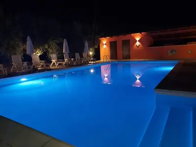 a swimming pool at night with blue lights at Borgomare in Campofelice di Roccella