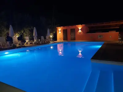 a swimming pool with blue lights in the night at Borgomare in Campofelice di Roccella