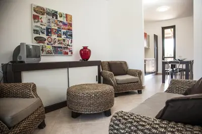 a living room with chairs and a tv on a table at Borgomare in Campofelice di Roccella
