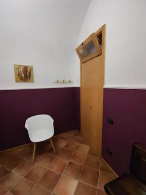 a room with a white chair and a door at Casa Frufa in Terrasini