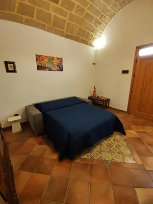 a bedroom with a bed with a blue bedspread on it at Casa Frufa in Terrasini