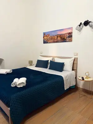 a bedroom with a large bed with blue sheets and white pillows at Manuè's House in Palermo