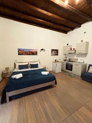 a bedroom with a large bed and a kitchen at Manuè's House in Palermo