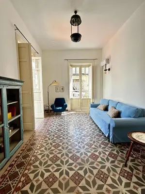 a living room with a blue couch and a fireplace at Casa Mediterraneo in Palermo
