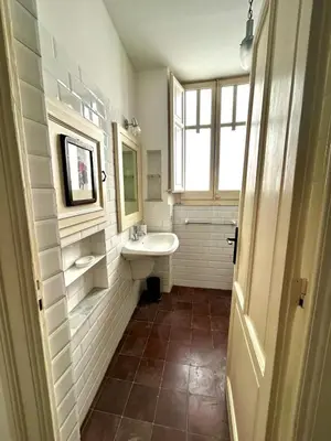 a white bathroom with a sink and a window at Casa Mediterraneo in Palermo