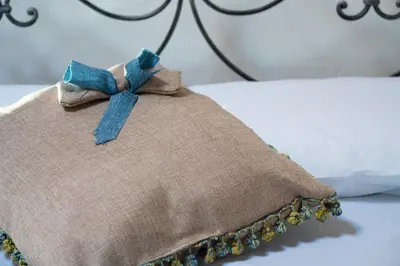 a brown pillow with a blue bow on a bed at Rooms Parrinelli in Partinico