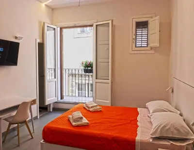 a bedroom with a bed with towels on it at Ostello Vucciria in Palermo