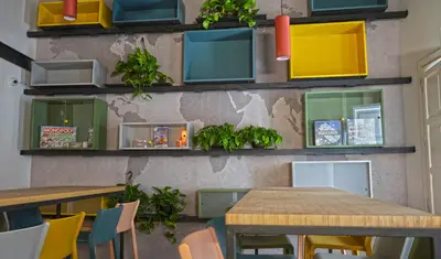 a restaurant with tables and chairs and boxes on the wall at Ostello Vucciria in Palermo