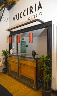 a reception desk in a lobby with a sign that reads vucati offline at Ostello Vucciria in Palermo