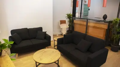 a living room with two couches and a table at Ostello Vucciria in Palermo