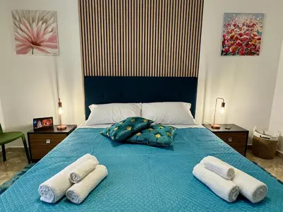 a bed with towels on it with a blue blanket at Beautiful Dimora Anna e Ciccio in Casteldaccia
