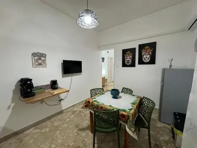 a room with a table and chairs and a television at Beautiful Dimora Anna e Ciccio in Casteldaccia