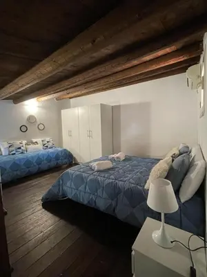 a bedroom with two beds and a table with a lamp at Casa di Reginaldo al Capo in Palermo
