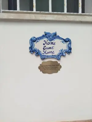 a sign that says home sweet home on a wall at Sea Diamond in Santa Flavia