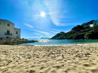 a sandy beach with the sun in the sky at Sea Diamond in Santa Flavia