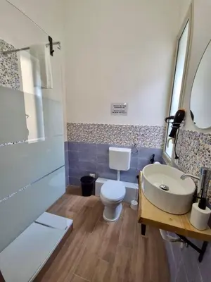 a bathroom with a toilet and a sink and a tub at Sicilia Bedda Room's in Palermo