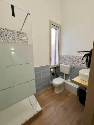 a bathroom with a toilet and a sink and a shower at Sicilia Bedda Room's in Palermo