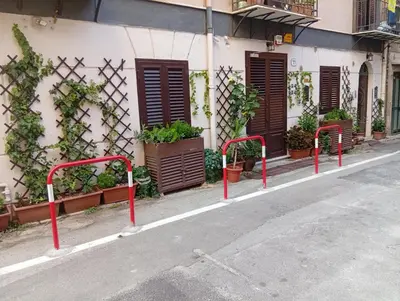 a row of red poles on the side of a street at Casa Emilia in Palermo
