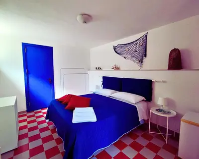 a bedroom with a blue bed and a red and white floor at A Casa da Mammi in Palermo