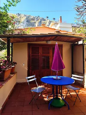 a table with two chairs and a pink umbrella on a patio at A Casa da Mammi in Palermo