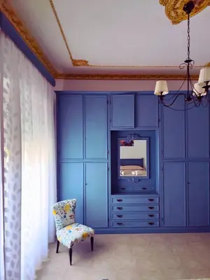 a blue room with a tv and a chair at A Casa da Mammi in Palermo