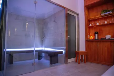 a glass shower with a bench in a room at B&B Del Centro e SPA in Partinico
