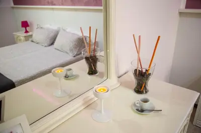 a white table with candles and vases in a room at B&B Del Centro e SPA in Partinico
