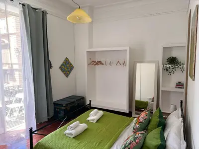 a bedroom with a green bed with two towels on it at Via Zara Arararooms in Palermo
