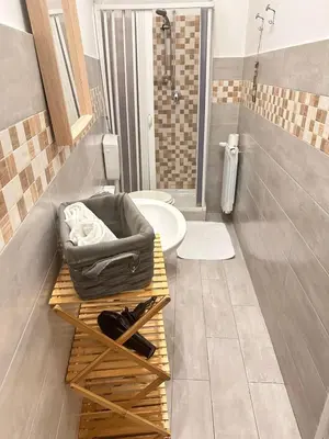 a bathroom with a shower and a toilet and a table at Via Zara Arararooms in Palermo
