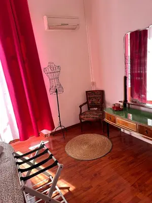 a living room with red curtains and a chair at Via Zara Arararooms in Palermo